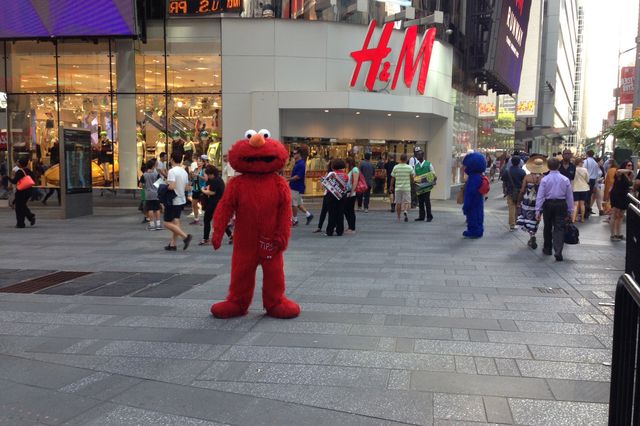 Elmo, with Cookie Monster in the background<br/>